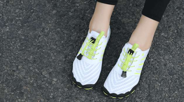 Person wearing white and neon green barefoot shoes